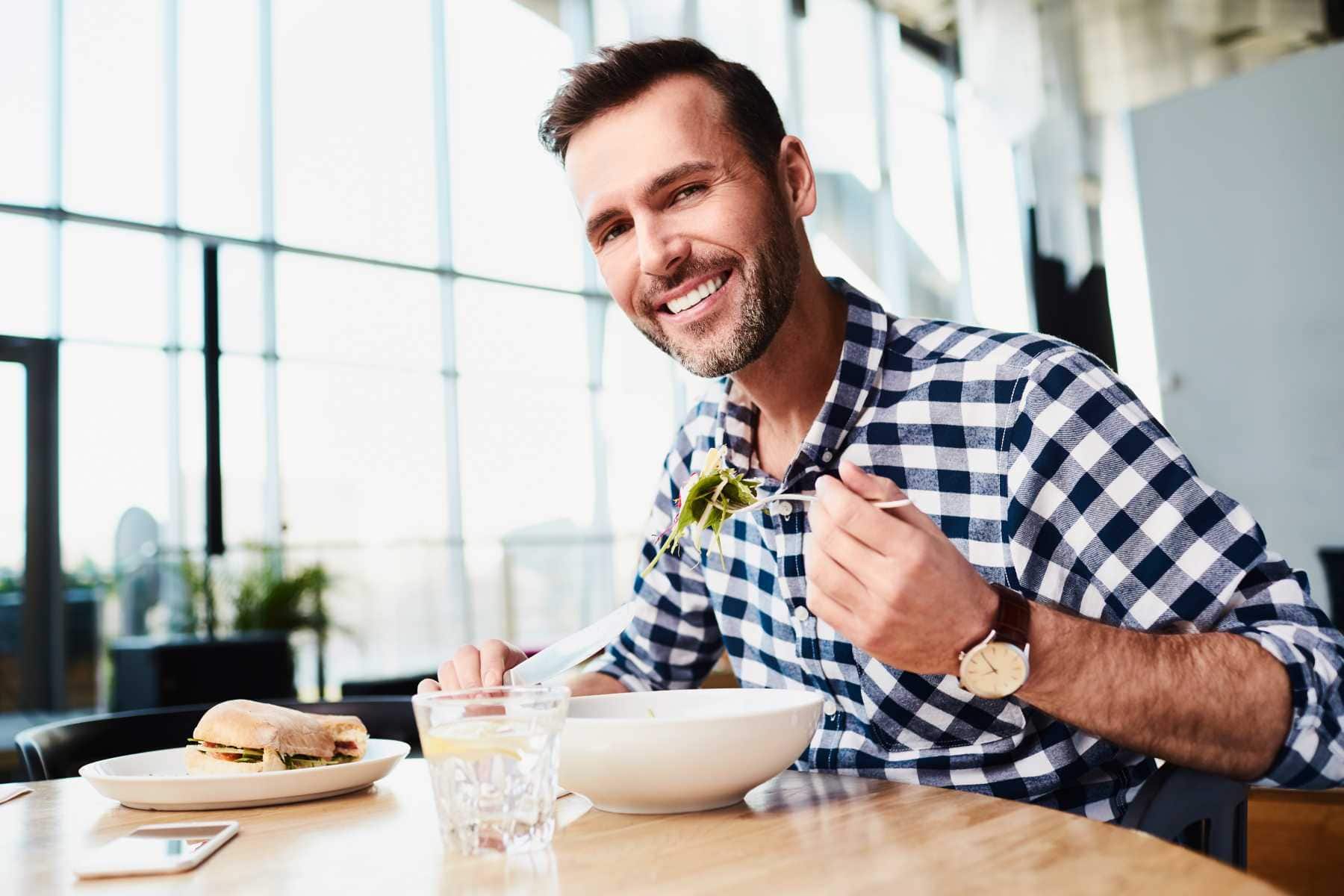 Man in office break room enjoying a healthy salad - Micro Market vs Vending Machines in the Office